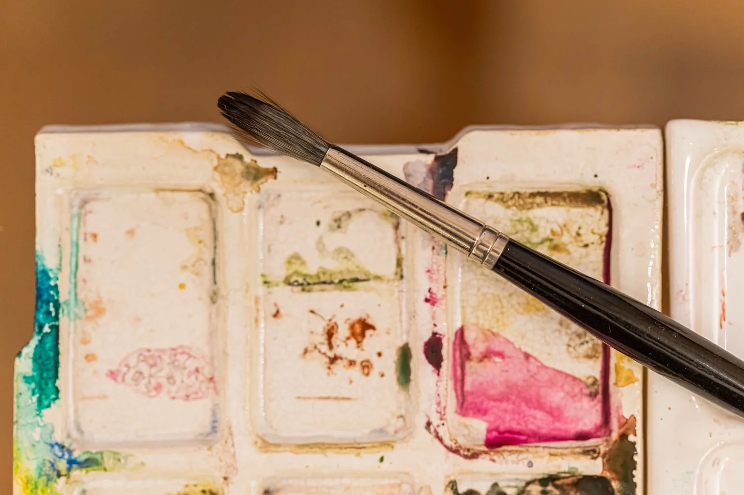 Paleta de aquarela usada, com pincel